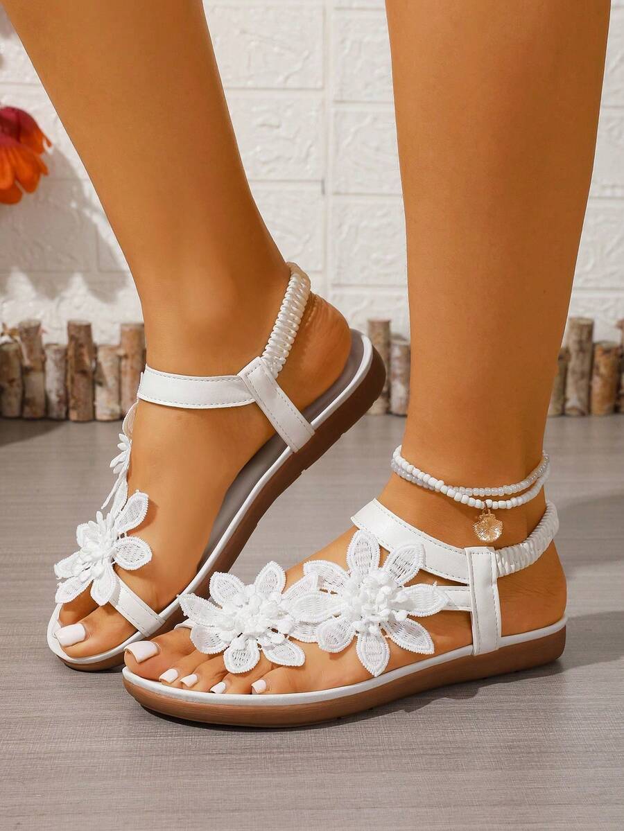 Women's lace-up flat slip-on sandals with round toe and hollow-out PU leather straps for beach and daily wear.