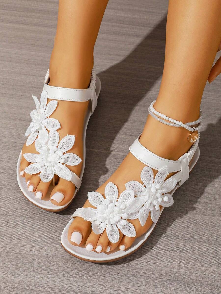 Women's lace-up flat slip-on sandals with round toe and hollow-out PU leather straps for beach and daily wear.