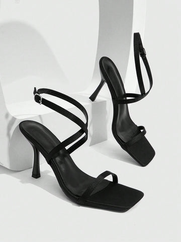 Pair of women's brown satin open toe stiletto sandals with cross ankle buckle straps.