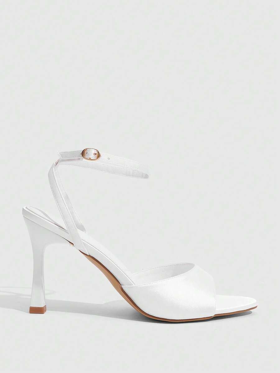 Women's pointed peep toe high heel stilettos featuring cross ankle strap with buckle in black PU leather.
