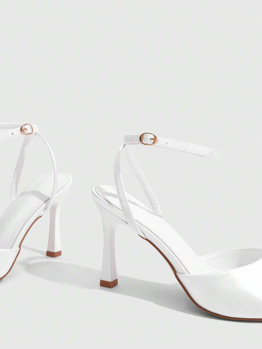 Women's pointed peep toe high heel stilettos featuring cross ankle strap with buckle in black PU leather.
