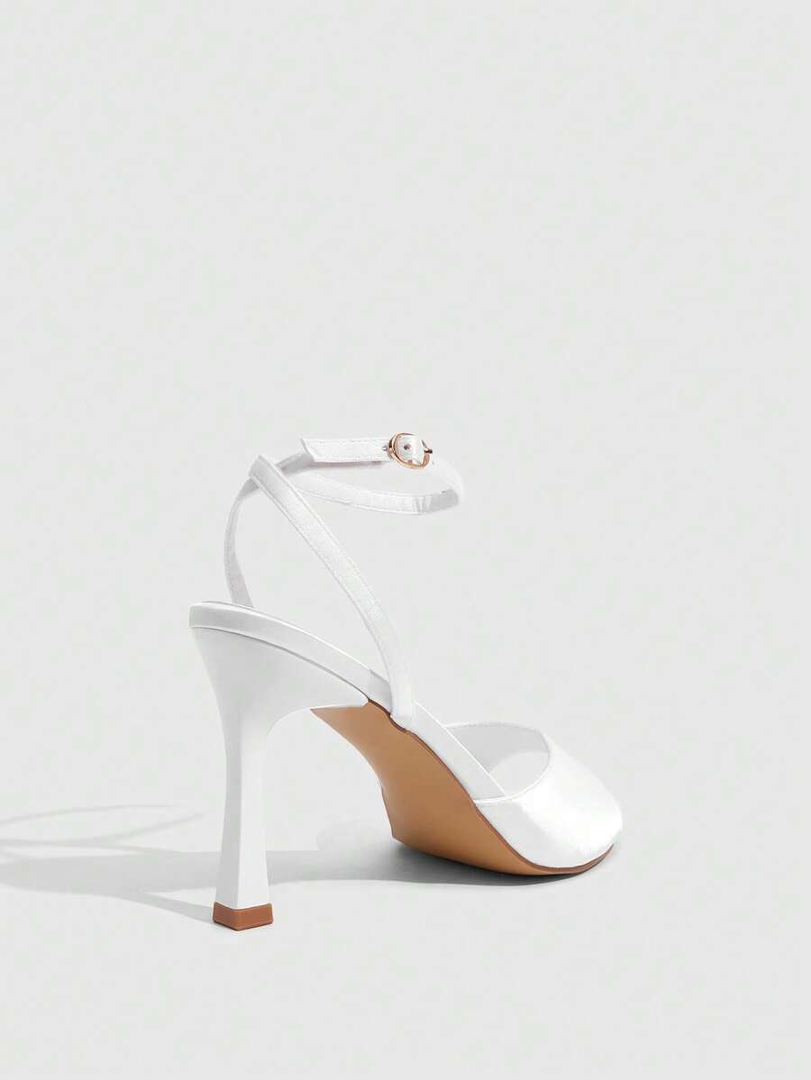 Women's pointed peep toe high heel stilettos featuring cross ankle strap with buckle in black PU leather.