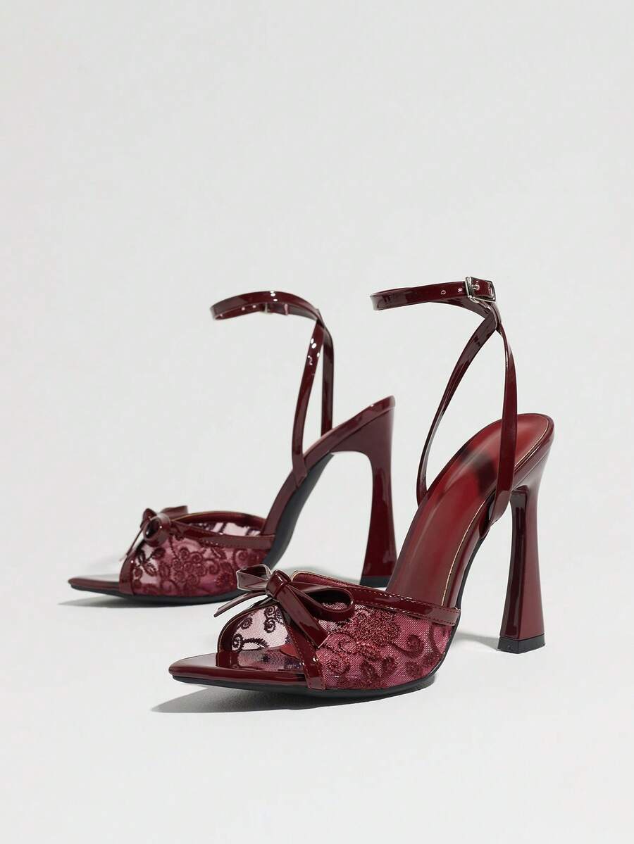 Burgundy open-toe high heels featuring an adjustable ankle strap with buckle closure and high stiletto heel.