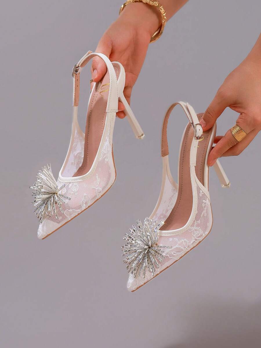White pointed toe high heel stiletto sandals featuring lace patchwork, fringe trim, and an oversized bowknot accent.