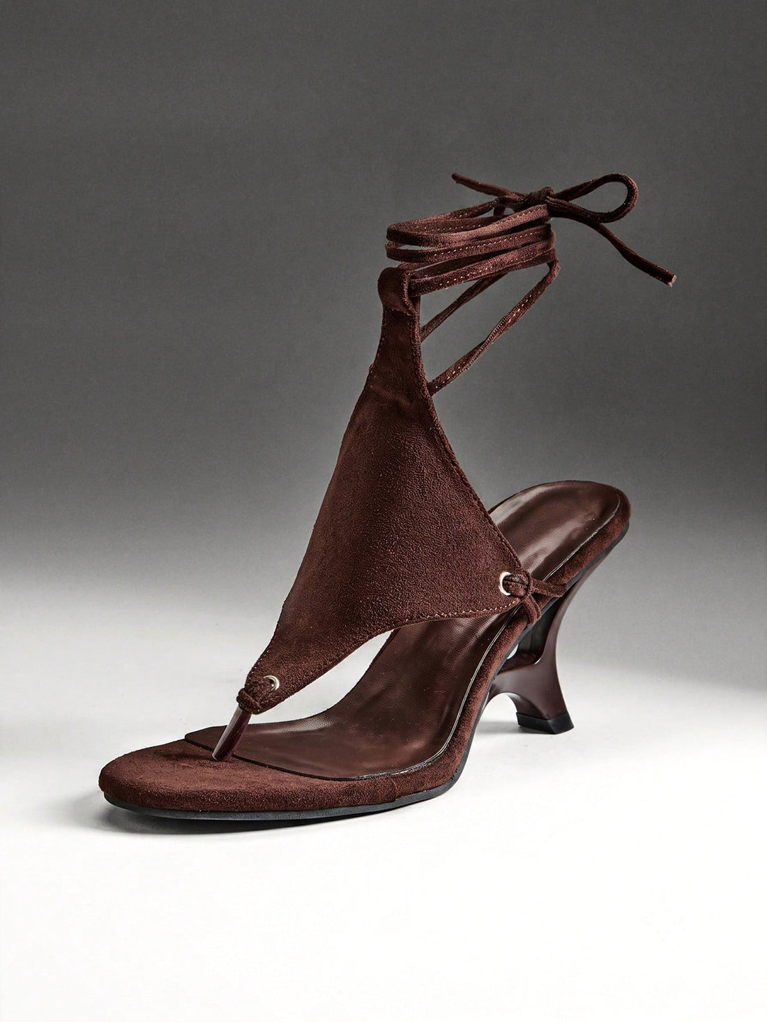 Chocolate brown women's lace-up leg wrap sculpted wedge thong sandals with strappy rope ties and textured high heel.