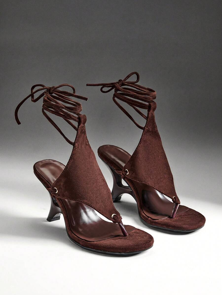Chocolate brown women's lace-up leg wrap sculpted wedge thong sandals with strappy rope ties and textured high heel.