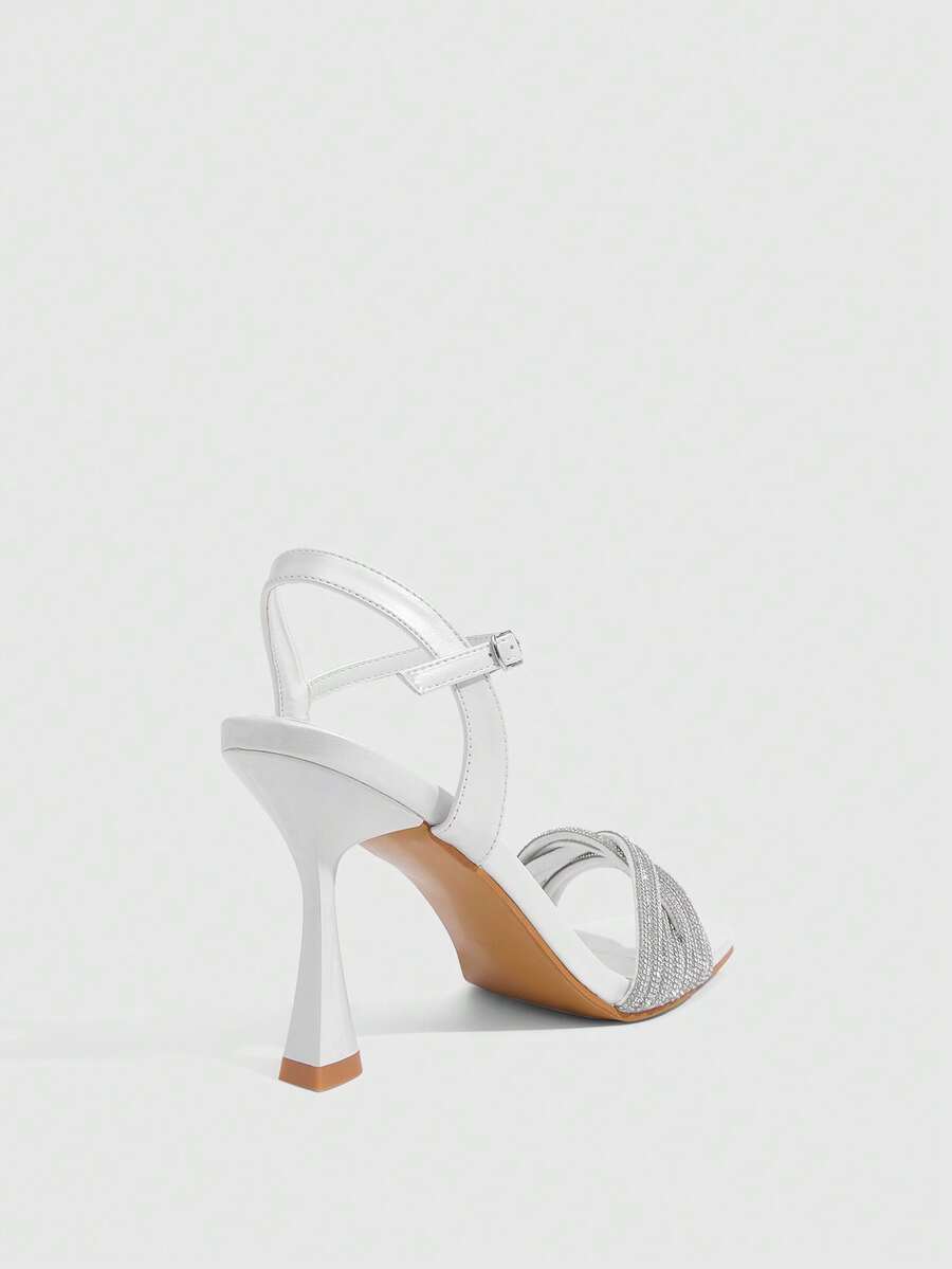 Women's gold open square toe high-heeled sandals featuring a stylish twist strap and stiletto heel.