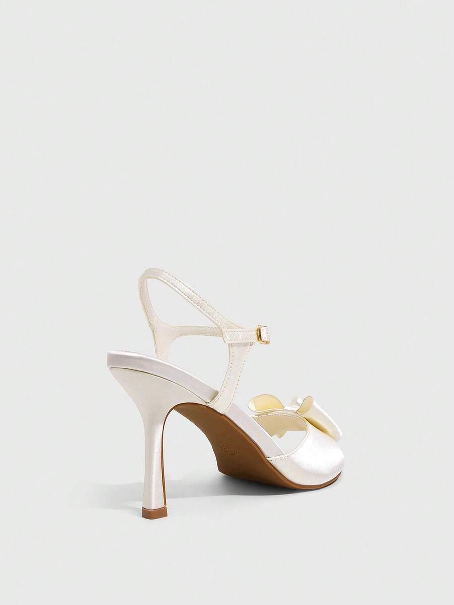 Elegant women's satin high heel sandals with pearl embellishments, stiletto heels, and slingback straps for bridal and wedding wear.