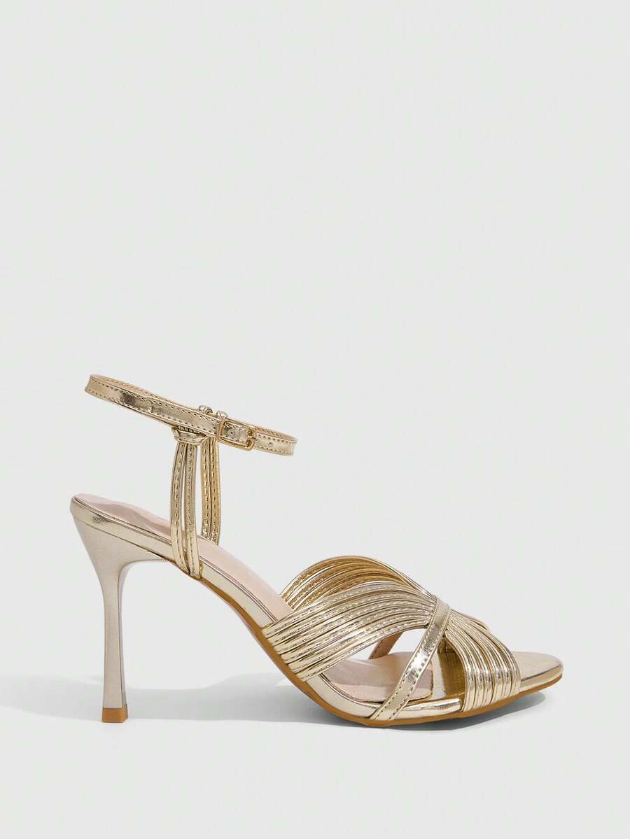 Women's champagne stiletto high heel sandals featuring knotted cross-over straps, open round toe, and adjustable ankle buckle strap.