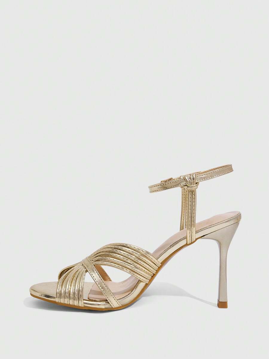 Women's champagne stiletto high heel sandals featuring knotted cross-over straps, open round toe, and adjustable ankle buckle strap.
