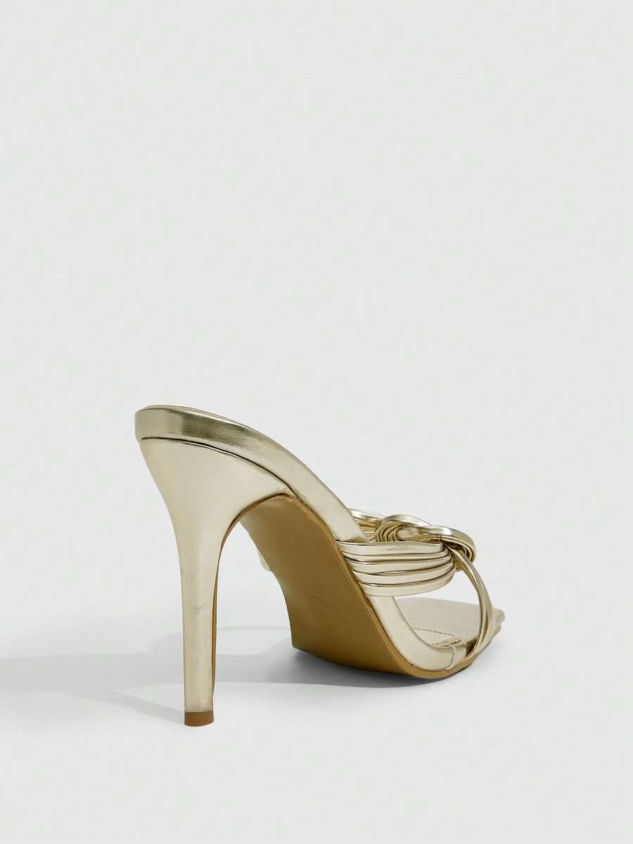 Women's gold open square toe high-heeled sandals featuring a stylish twist strap and stiletto heel.