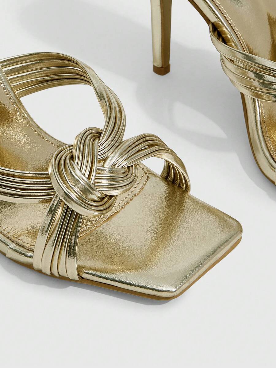 Women's gold open square toe high-heeled sandals featuring a stylish twist strap and stiletto heel.