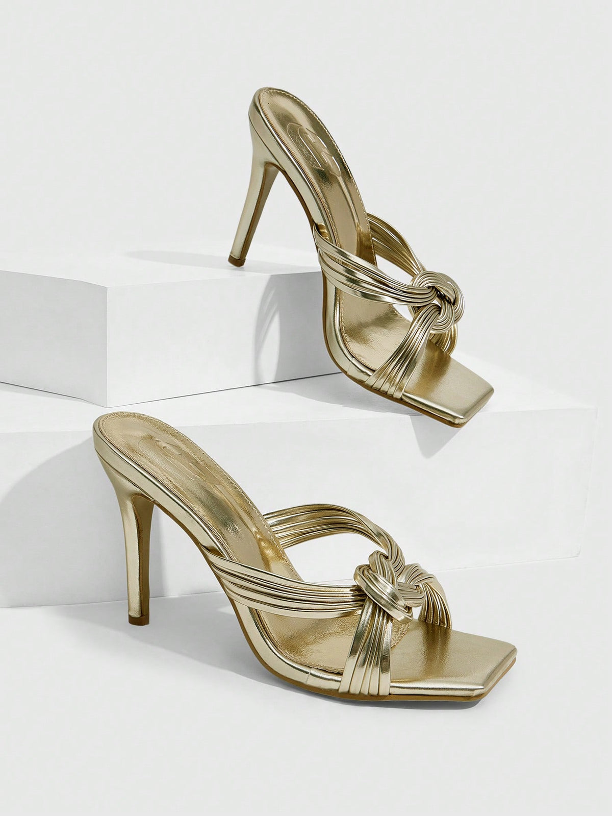 Women's gold open square toe high-heeled sandals featuring a stylish twist strap and stiletto heel.