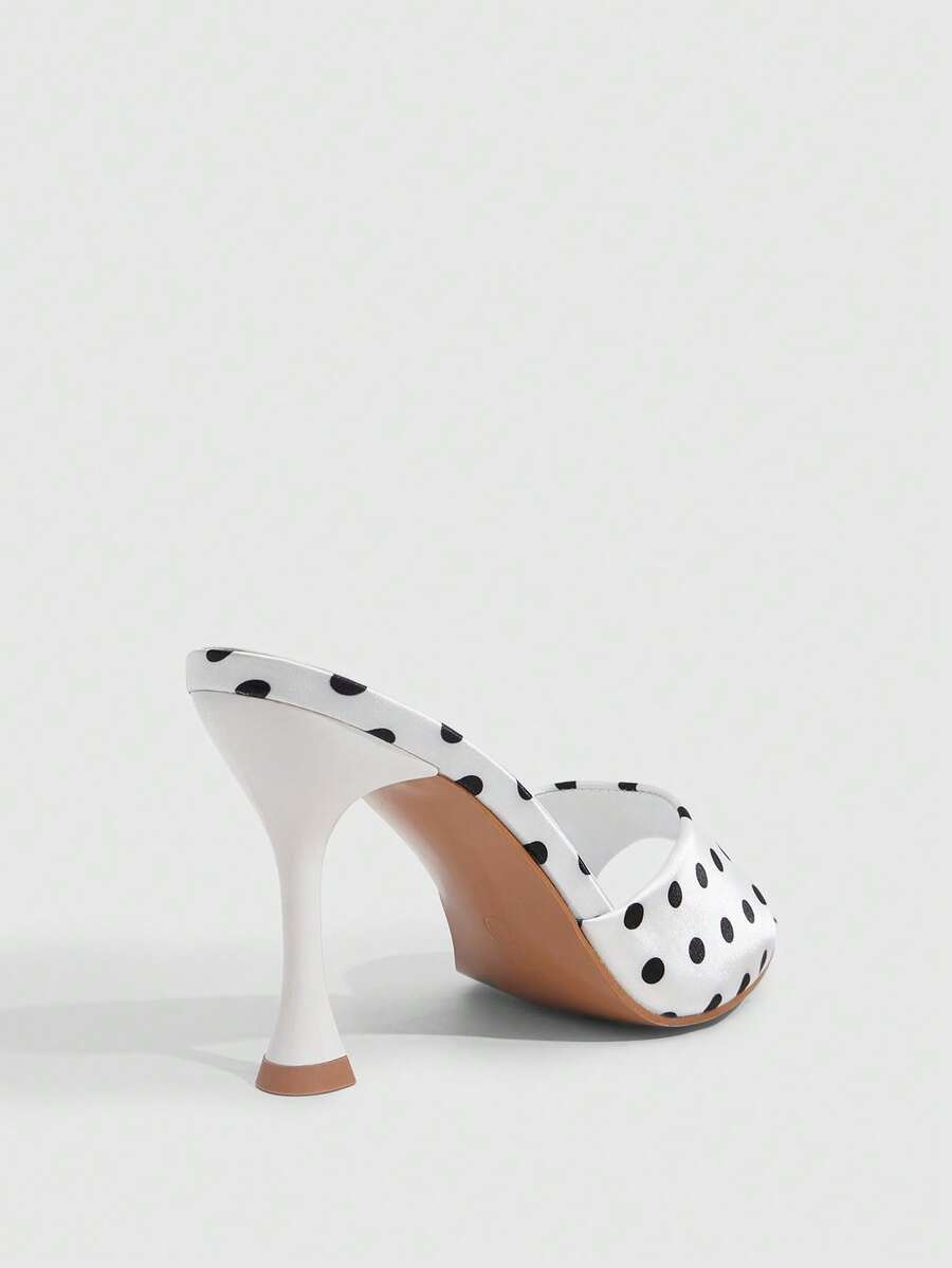 Pair of women's pointed toe stiletto mule sandals with shiny patent upper and slip-on design.