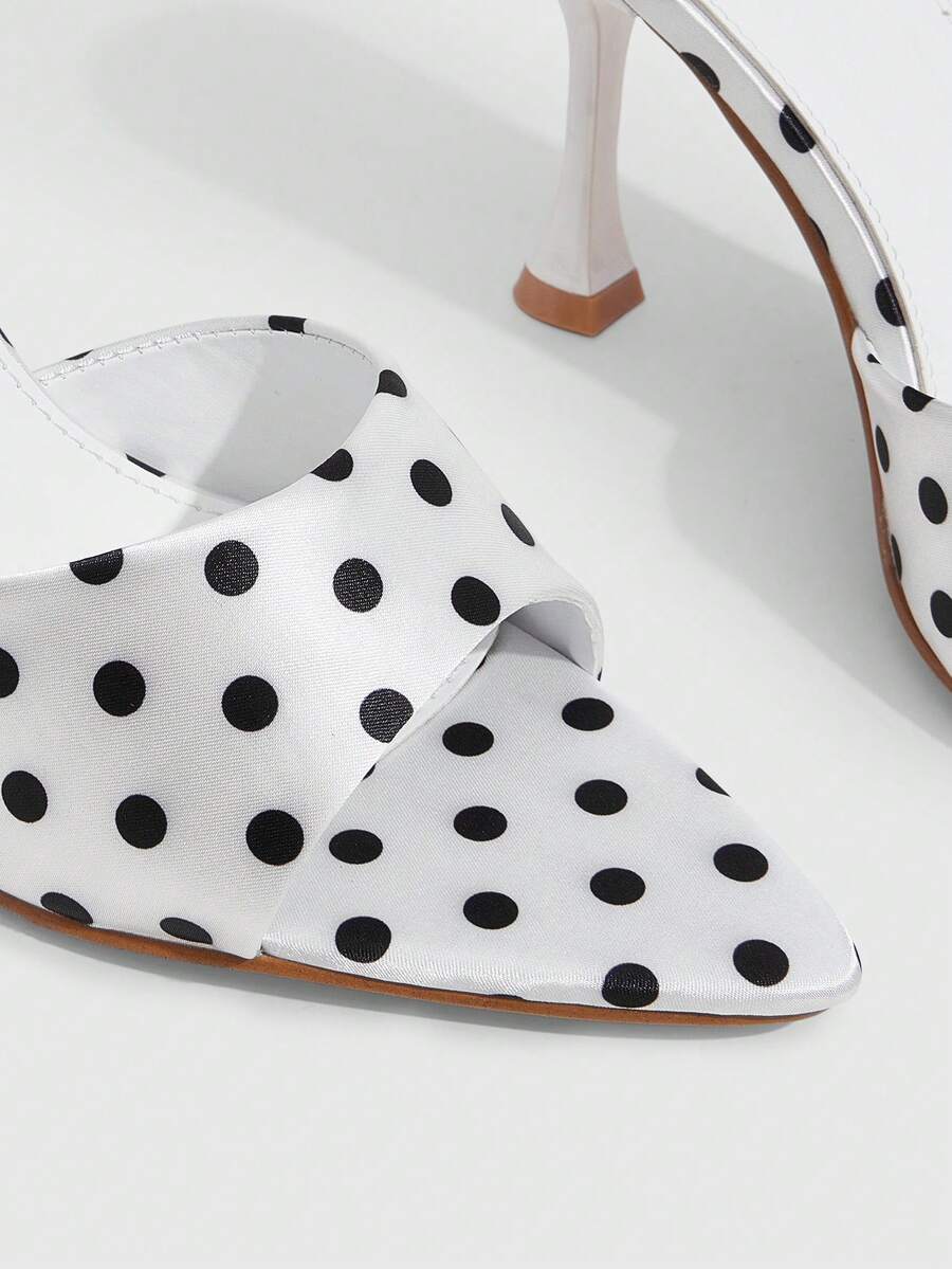 Pair of women's pointed toe stiletto mule sandals with shiny patent upper and slip-on design.