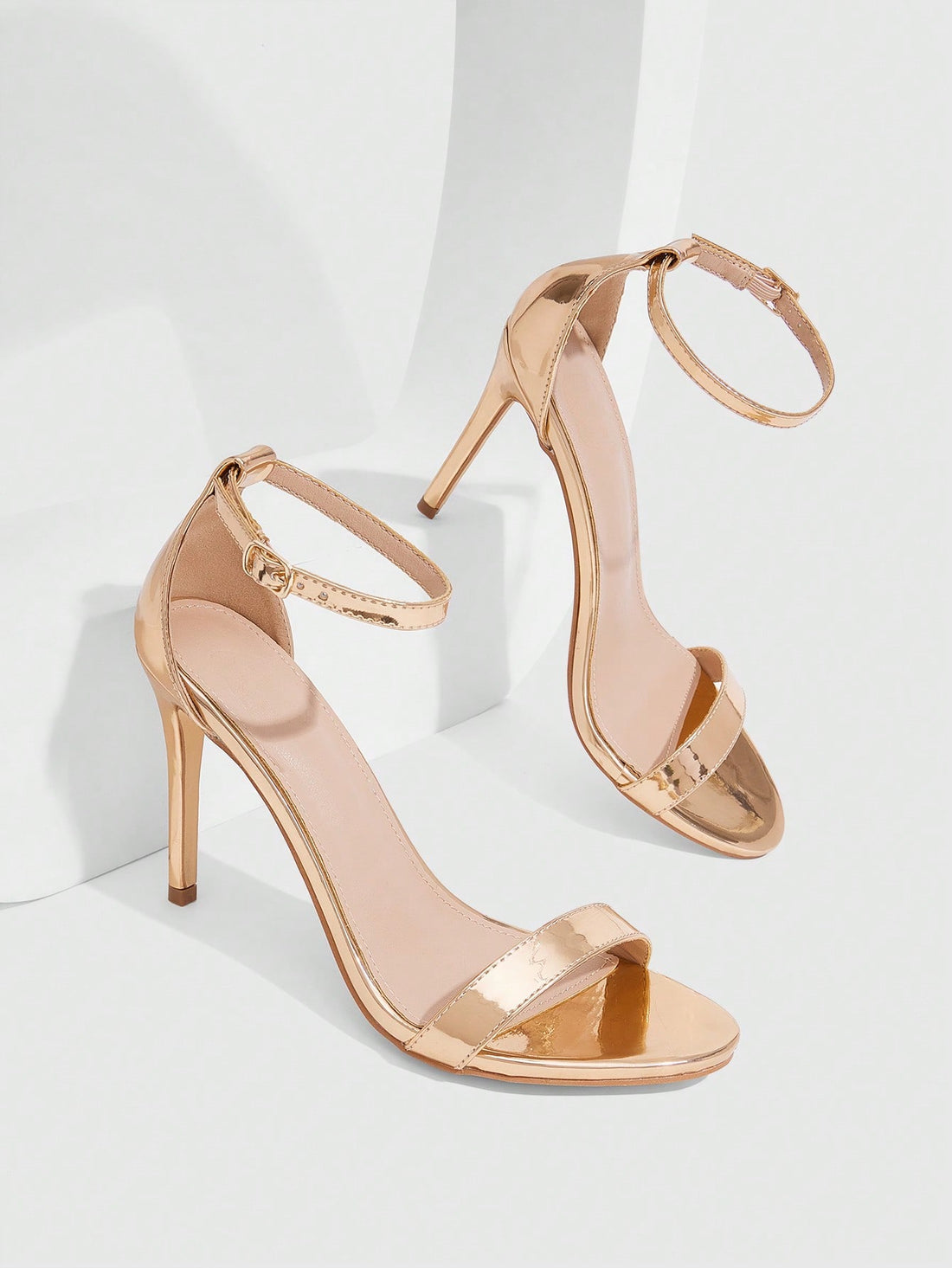 Women's stiletto sandals featuring an ankle strap buckle closure and classic round open toe design.