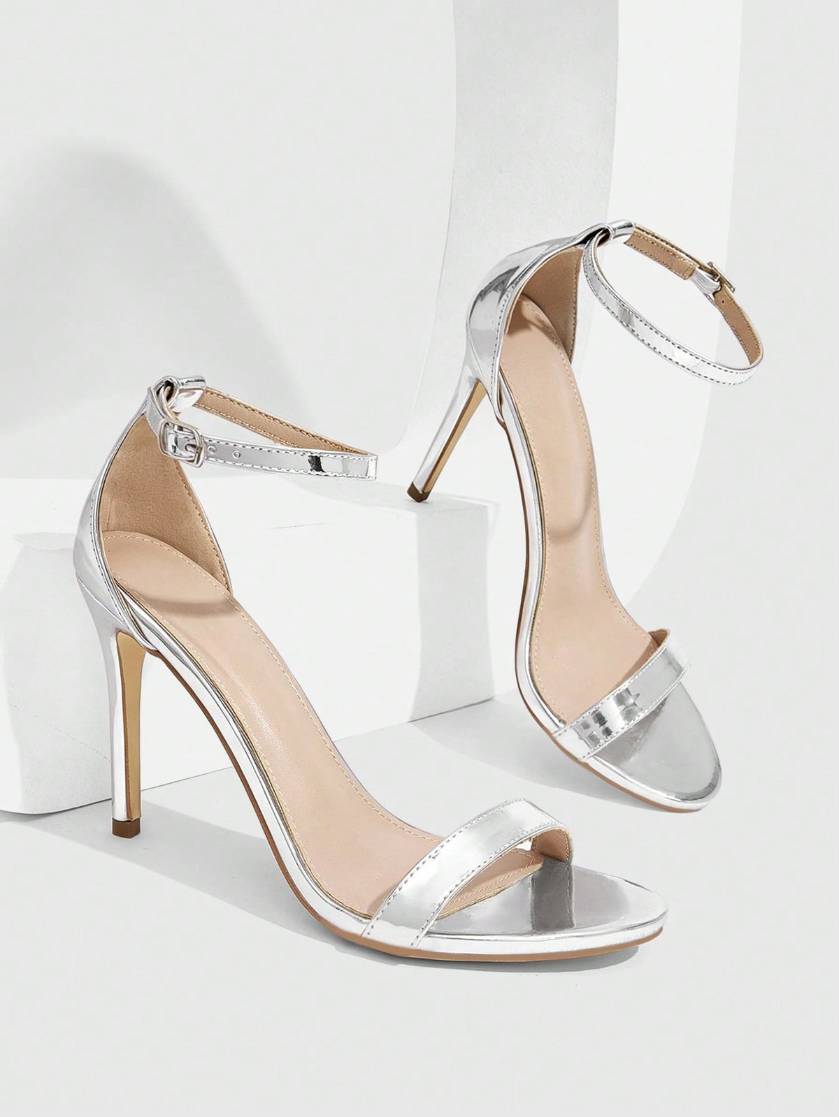 Women's stiletto sandals featuring an ankle strap buckle closure and classic round open toe design.