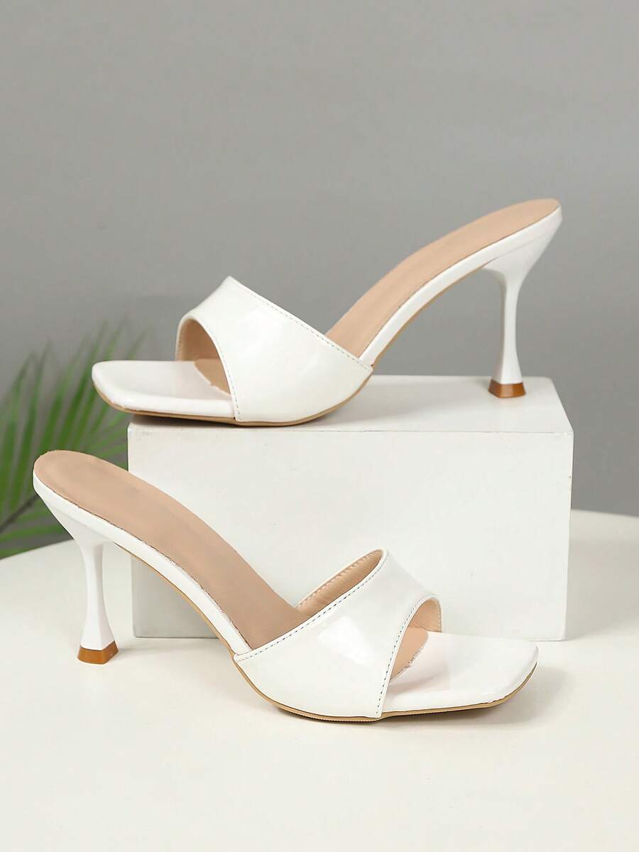 Black mirror finish open toe stiletto high heel slide sandals for women featuring crystal and sequin embellishments.