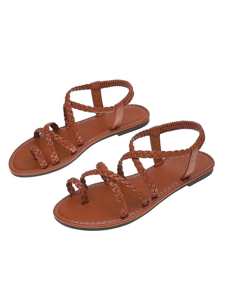 Flat sandals featuring thin criss-cross straps, elastic back strap, round toe post design, and smooth flat rubber sole.