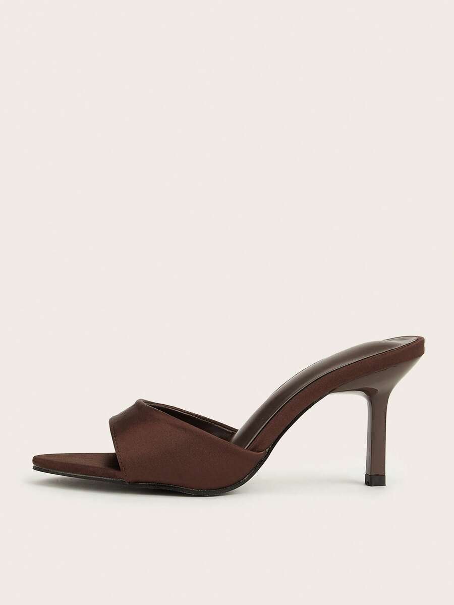 Brown cow print and polka dot stiletto high heel sandals with an open peep toe, satin upper, and buckle accent.