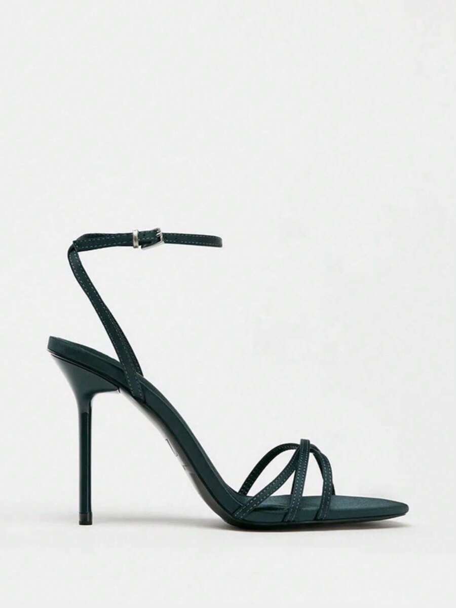 Women's open toe stiletto high heel sandals featuring metallic knot decor and an adjustable ankle buckle strap.