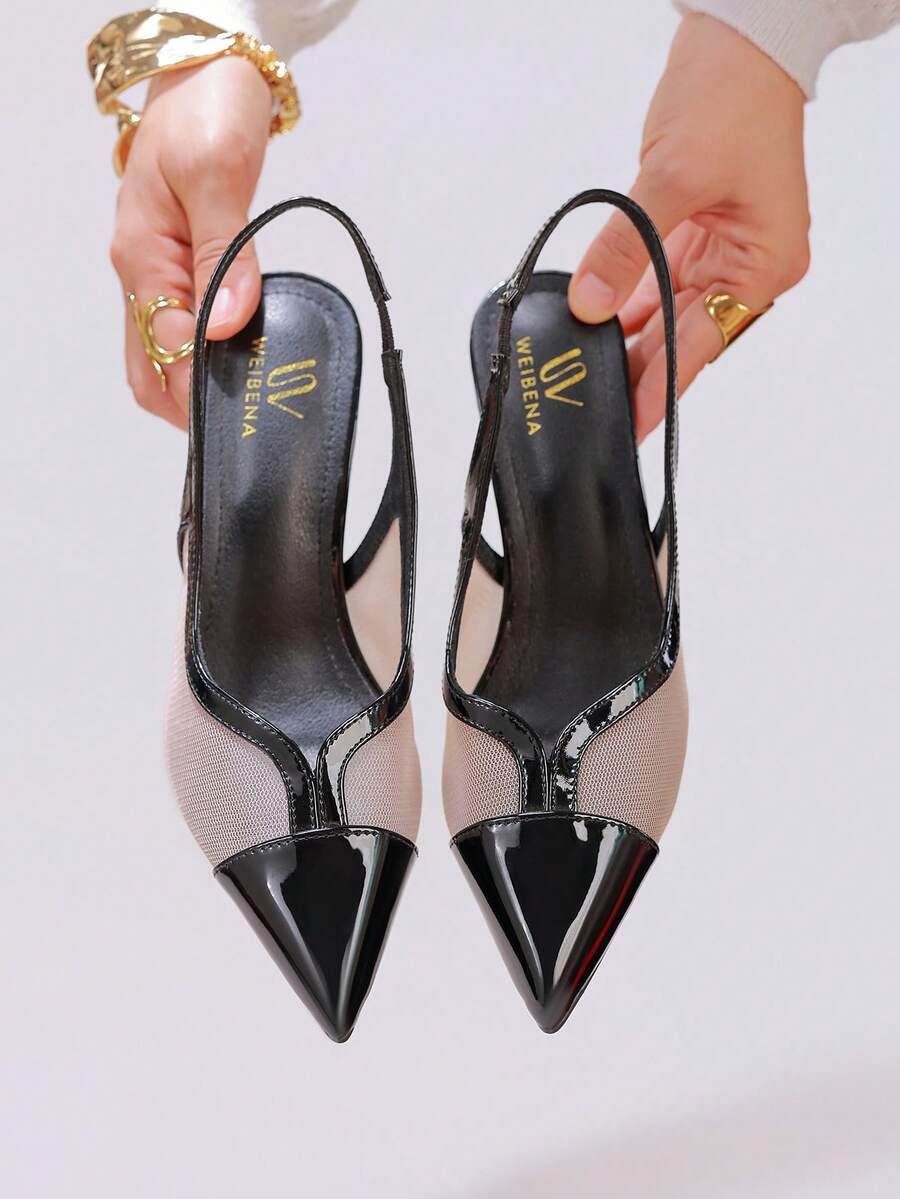 Pair of women's white pointed-toe kitten heel pumps with slingback straps and sleek patent finish
