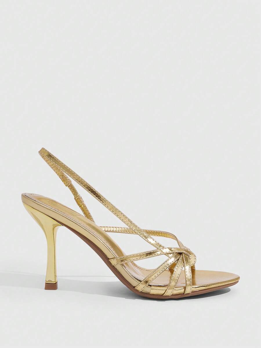 Women's open-toed stiletto high-heeled sandals in glossy patent black featuring twist strap detailing and slingback design.