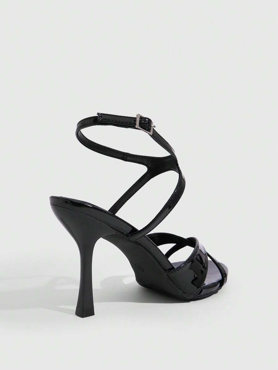Women's glossy patent leather stiletto sandals in burgundy with open toe design and buckle strap closure.