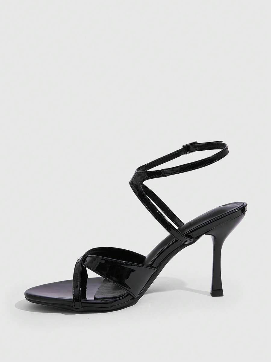 Women's glossy patent leather stiletto sandals in burgundy with open toe design and buckle strap closure.