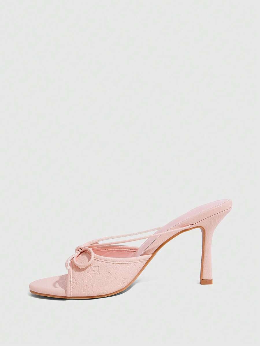 Elegant high heel sandals with romantic bow strap and slim stiletto heel for party and wedding occasions.