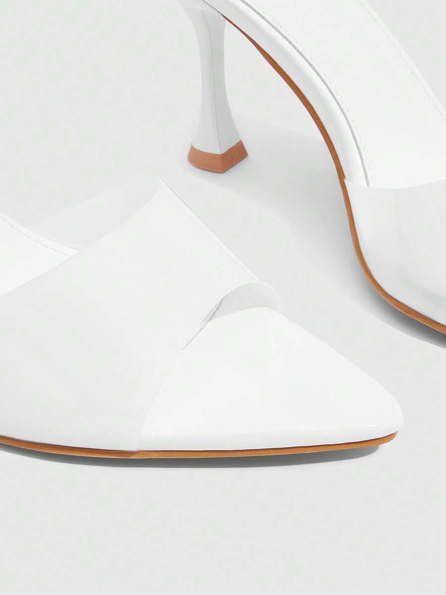 Pair of women's pointed toe stiletto mule sandals with shiny patent upper and slip-on design.