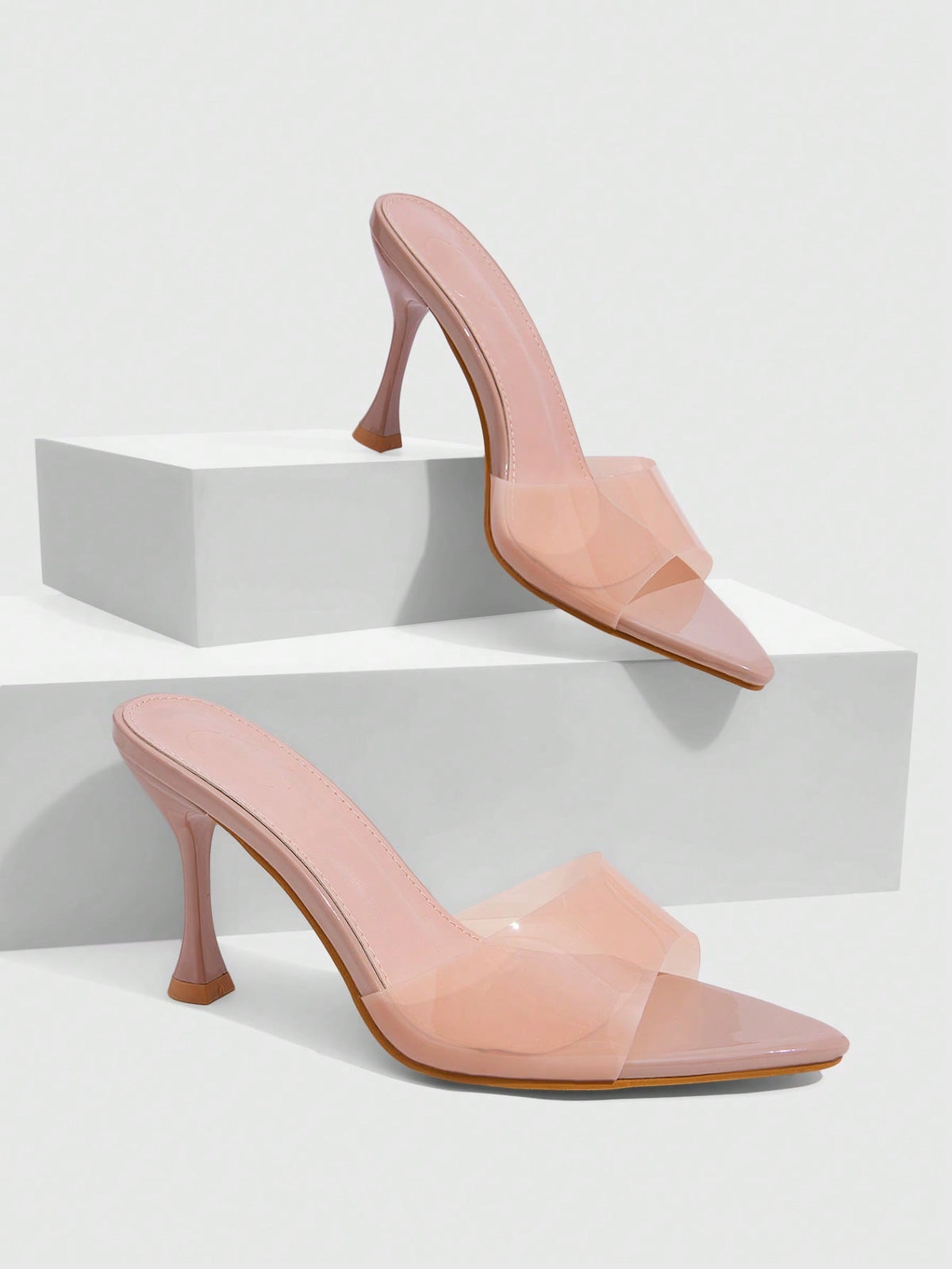 Pair of women's pointed toe stiletto mule sandals with shiny patent upper and slip-on design.