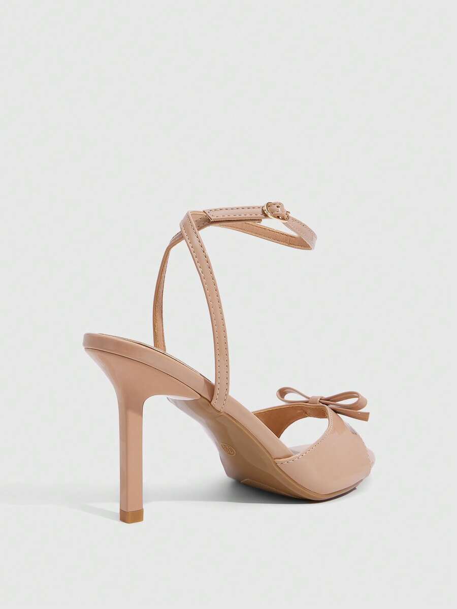 Women's pointed peep toe high heel stilettos featuring cross ankle strap with buckle in black PU leather.