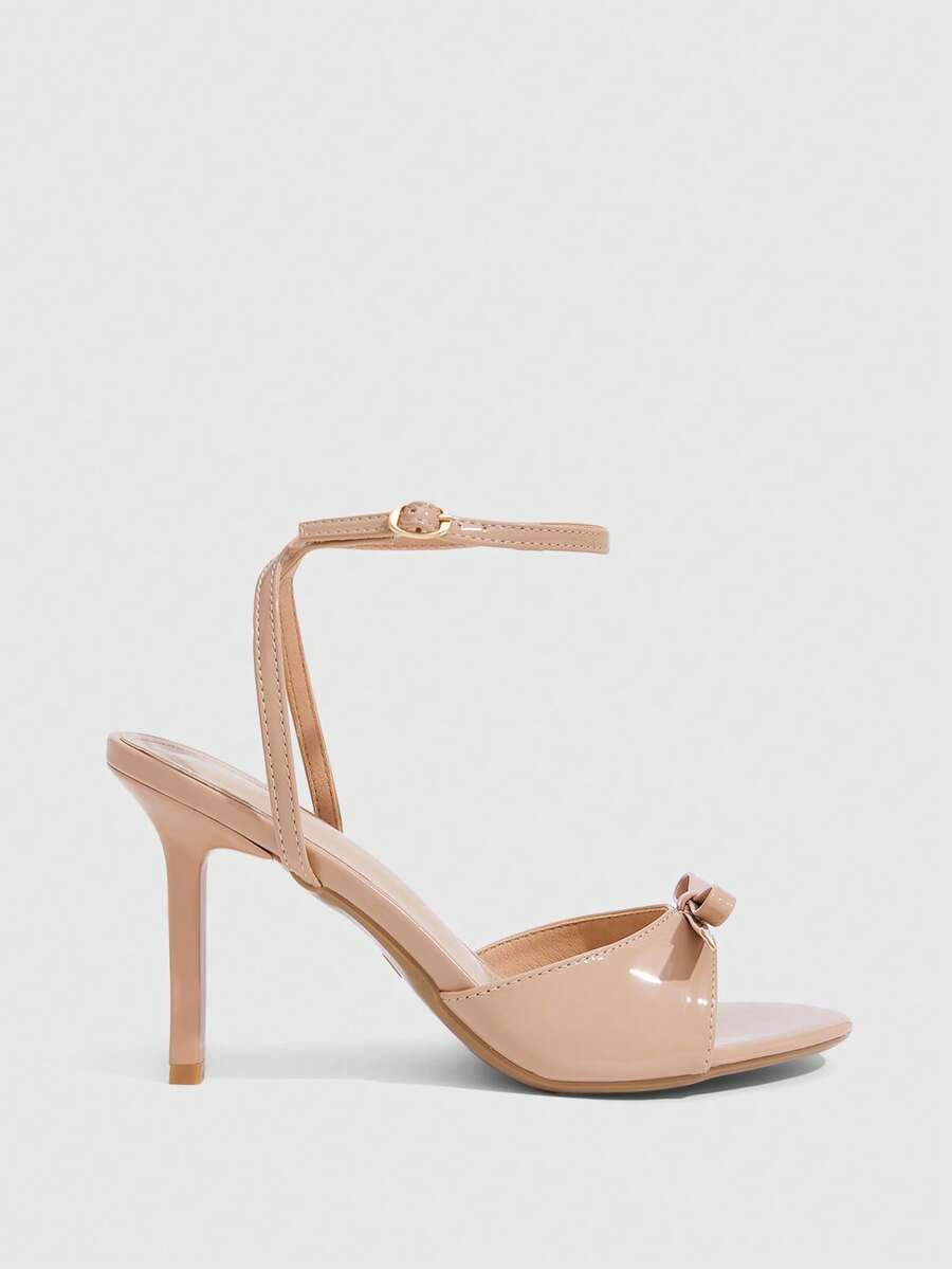 Women's pointed peep toe high heel stilettos featuring cross ankle strap with buckle in black PU leather.