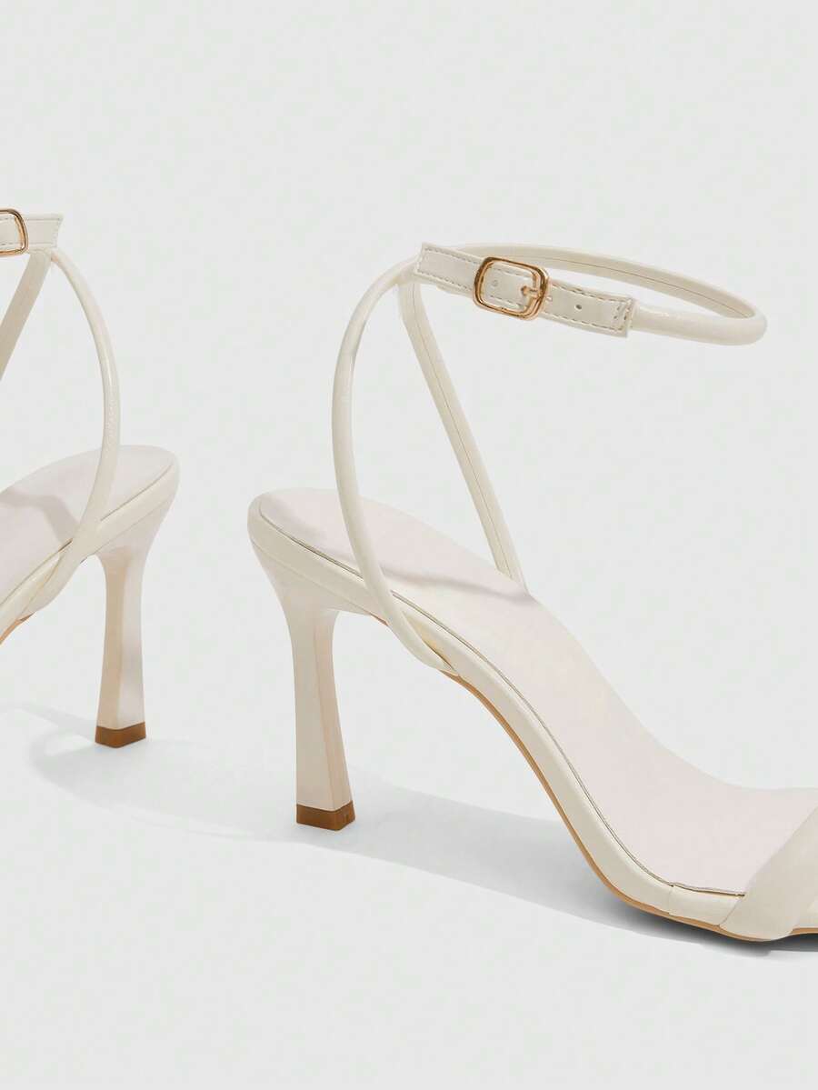 Women's high heel ankle strap sandals with open toe and stiletto heel in mirror black finish.
