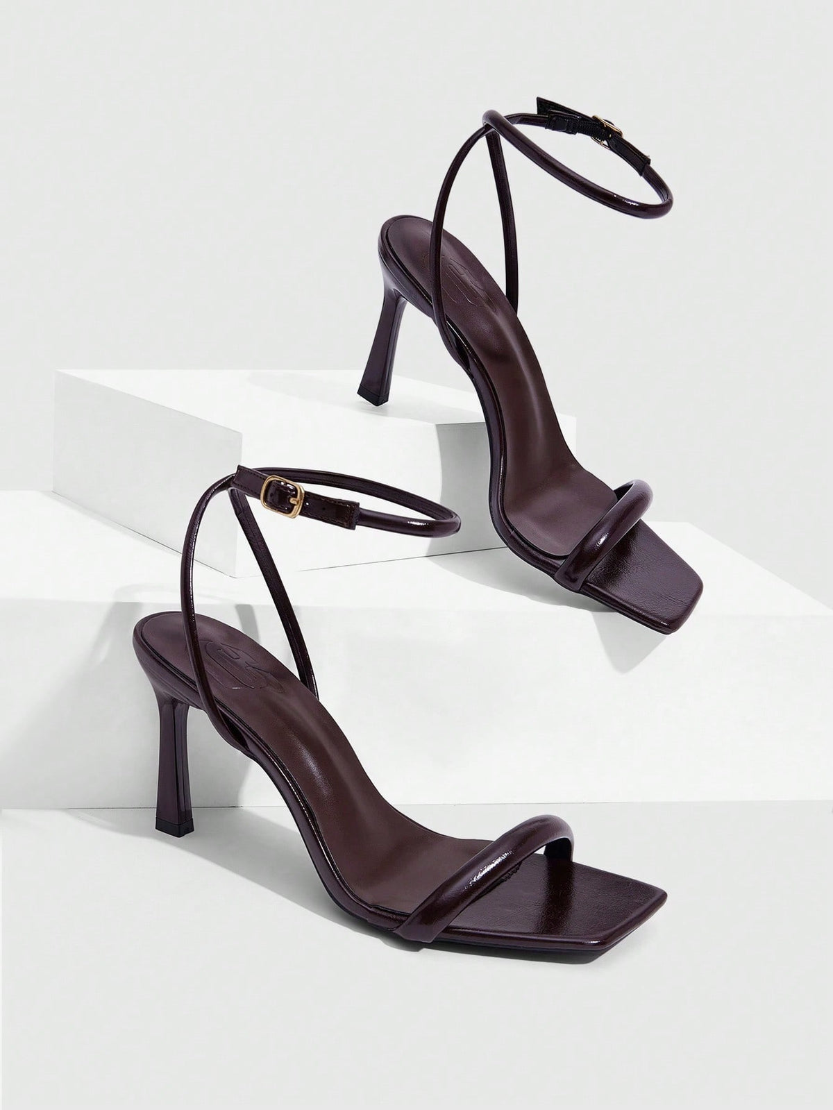 Women's high heel ankle strap sandals with open toe and stiletto heel in mirror black finish.