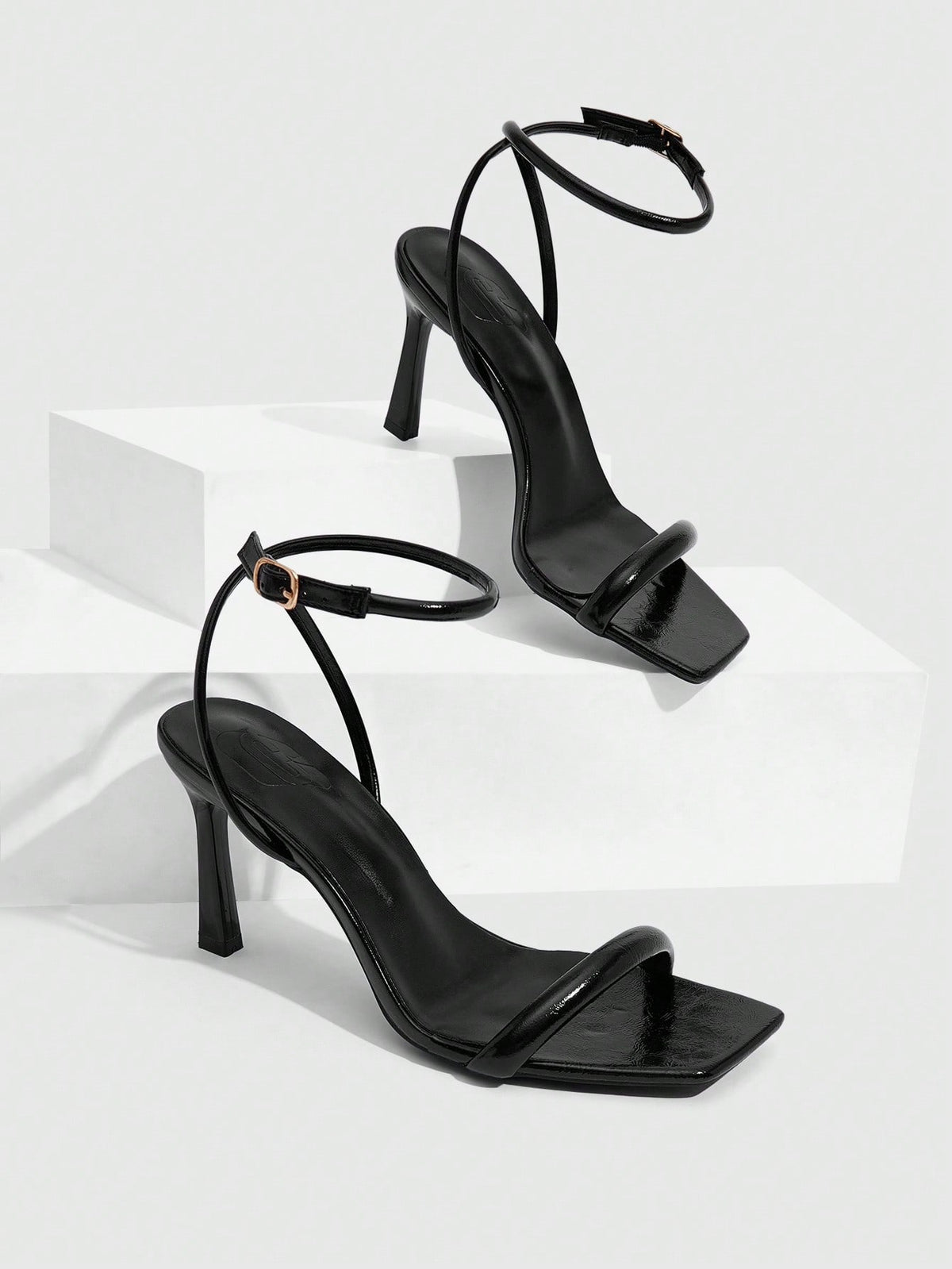 Women's high heel ankle strap sandals with open toe and stiletto heel in mirror black finish.