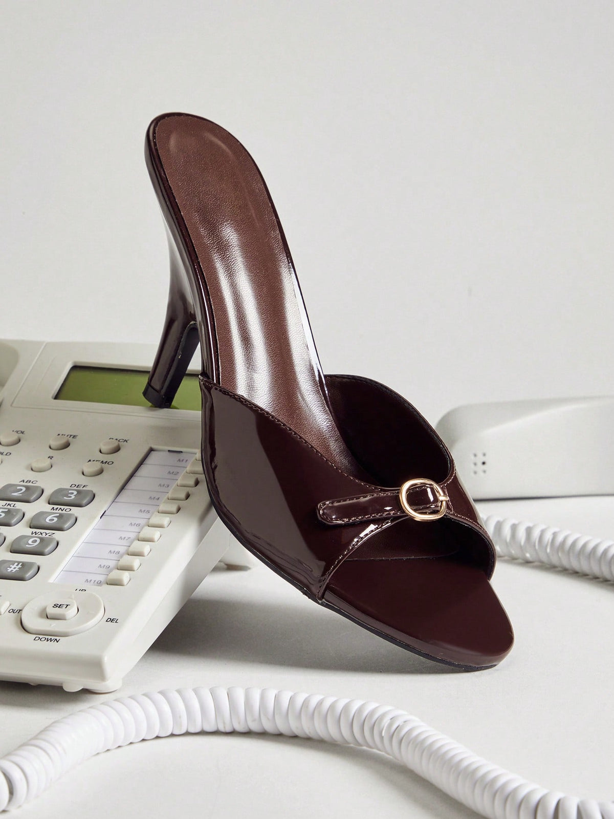 Women's slip-on heeled sandals with metal-coated stiletto heels and lock decoration in chocolate brown PU leather.
