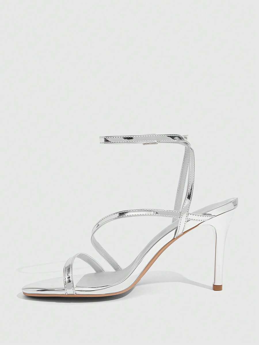 Women's silver stiletto high-heeled sandals with cross straps, buckle fastening, and open round toe.