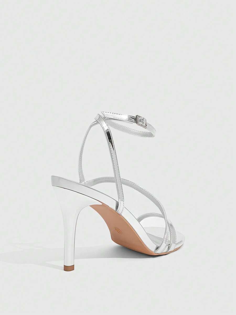 Women's silver stiletto high-heeled sandals with cross straps, buckle fastening, and open round toe.