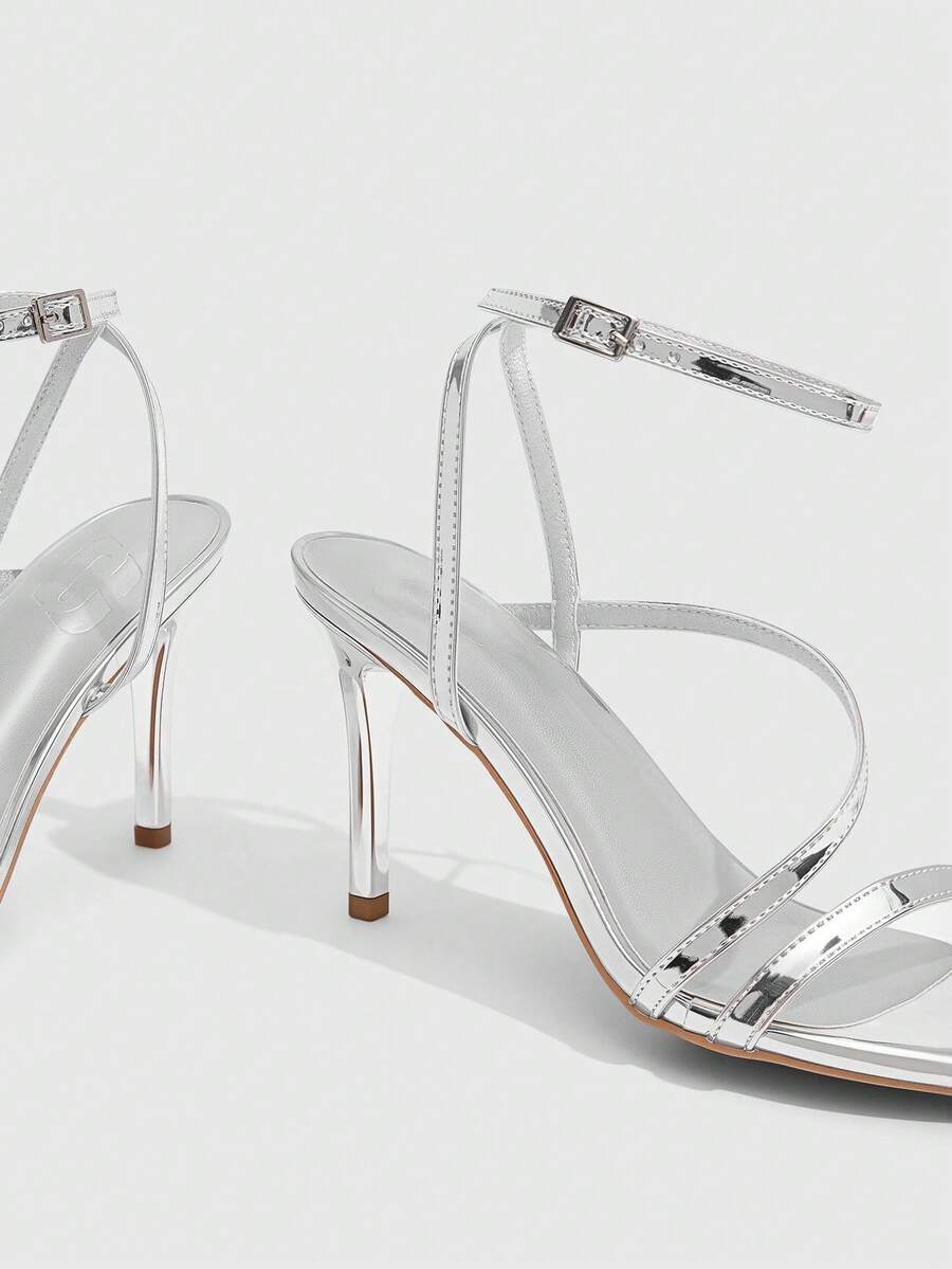Women's silver stiletto high-heeled sandals with cross straps, buckle fastening, and open round toe.