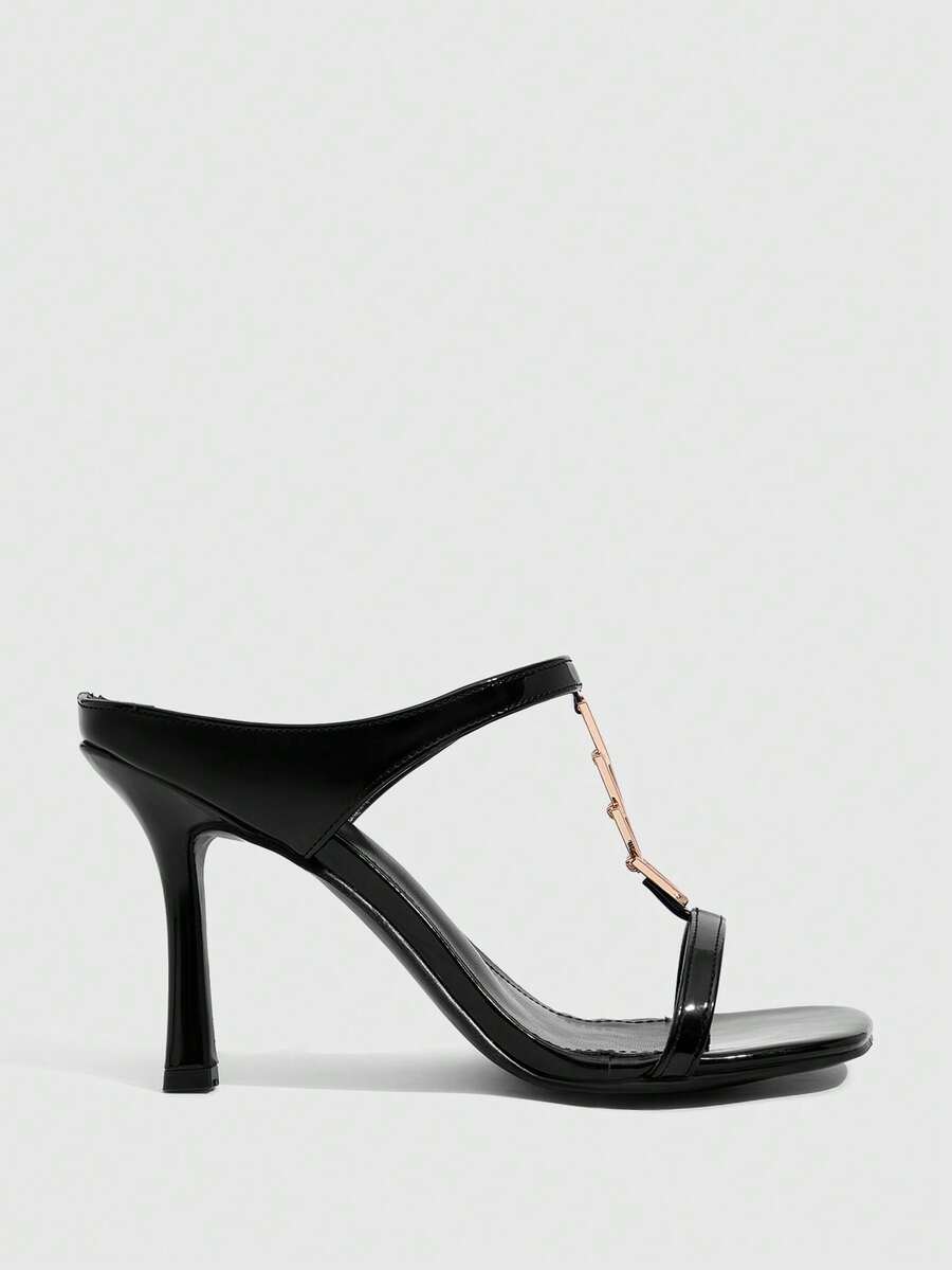 Women's black patent leather slip-on heeled sandals featuring a square toe, gold metal hardware, and sleek stiletto heels.