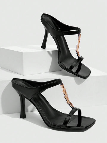 Women's black patent leather slip-on heeled sandals featuring a square toe, gold metal hardware, and sleek stiletto heels.