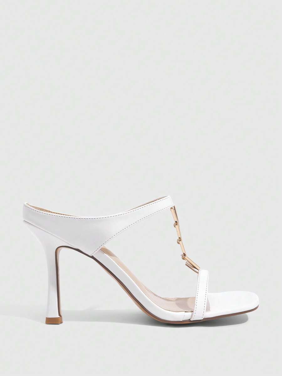 Women's black patent leather slip-on heeled sandals featuring a square toe, gold metal hardware, and sleek stiletto heels.