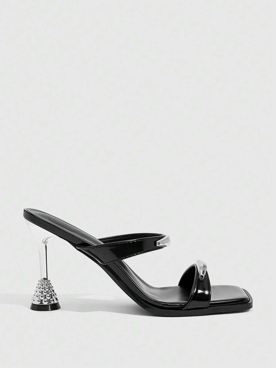 Women's black high-heeled sandals featuring an open square toe, stiletto heel, and decorative metal buckle strap detail.