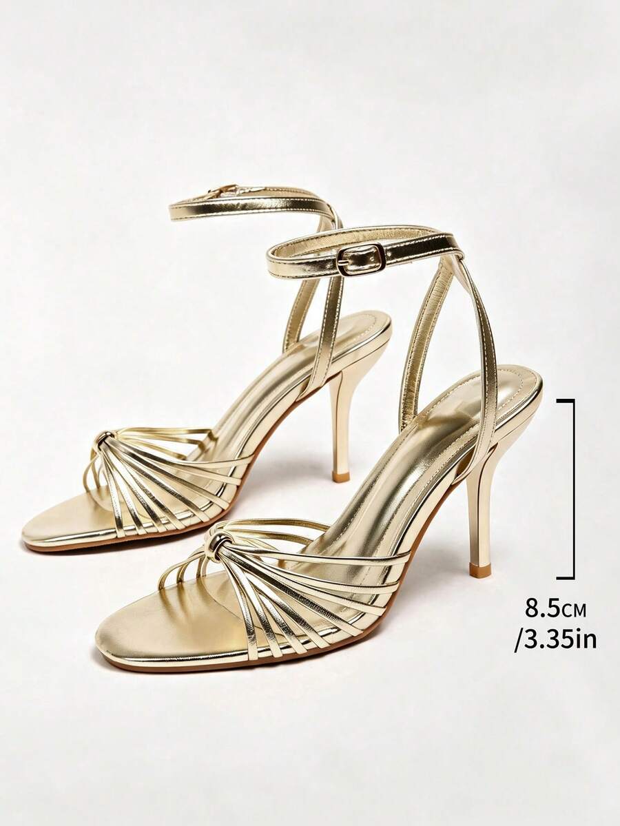 Women's open toe stiletto high heel sandals featuring metallic knot decor and an adjustable ankle buckle strap.