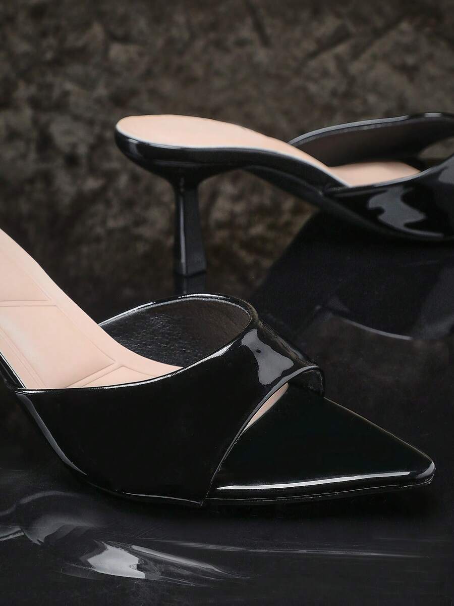 Black pointy toe kitten heel shoes for women featuring a sleek cut out mule design and glossy patent leather finish.