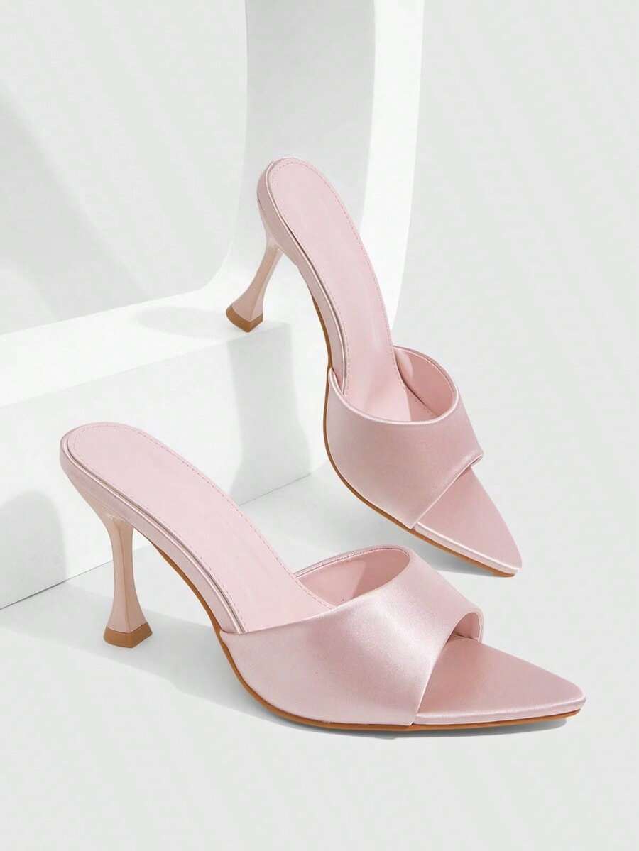 Pair of women's pointed toe stiletto mule sandals with shiny patent upper and slip-on design.