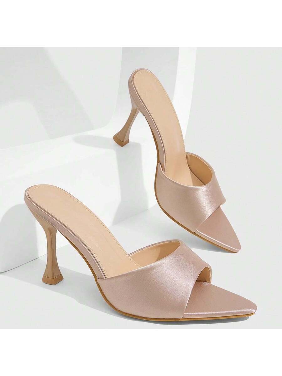 Pair of women's pointed toe stiletto mule sandals with shiny patent upper and slip-on design.