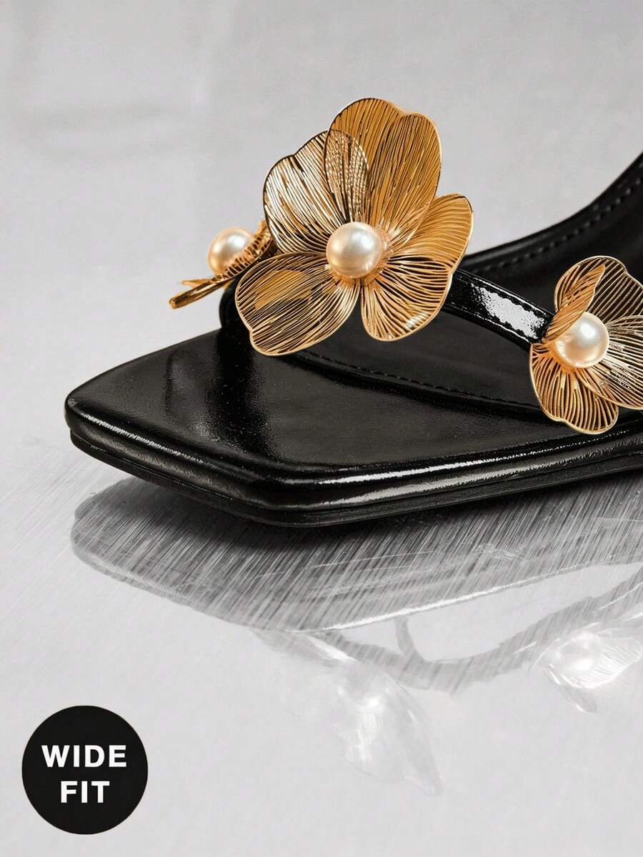 Women's metallic gold wide-fit high heeled sandals featuring stiletto heels, open toe straps, and elegant floral appliques.